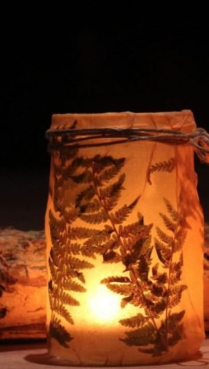 candles in brown decorative jars beside firewood Halloween 66