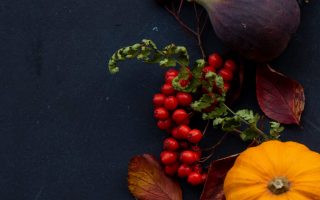 round Halloween themed wreath on blue surface autumn flatlay scaled