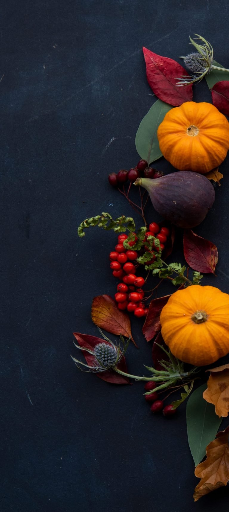round Halloween themed wreath on blue surface autumn flatlay scaled