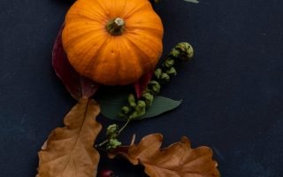 round Halloween themed wreath on blue surface autumn flatlay fall scaled