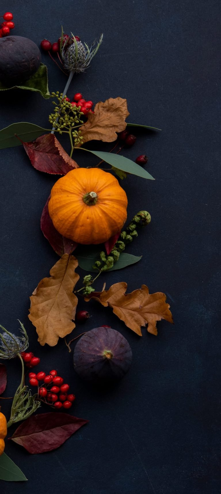 round Halloween themed wreath on blue surface autumn flatlay fall scaled